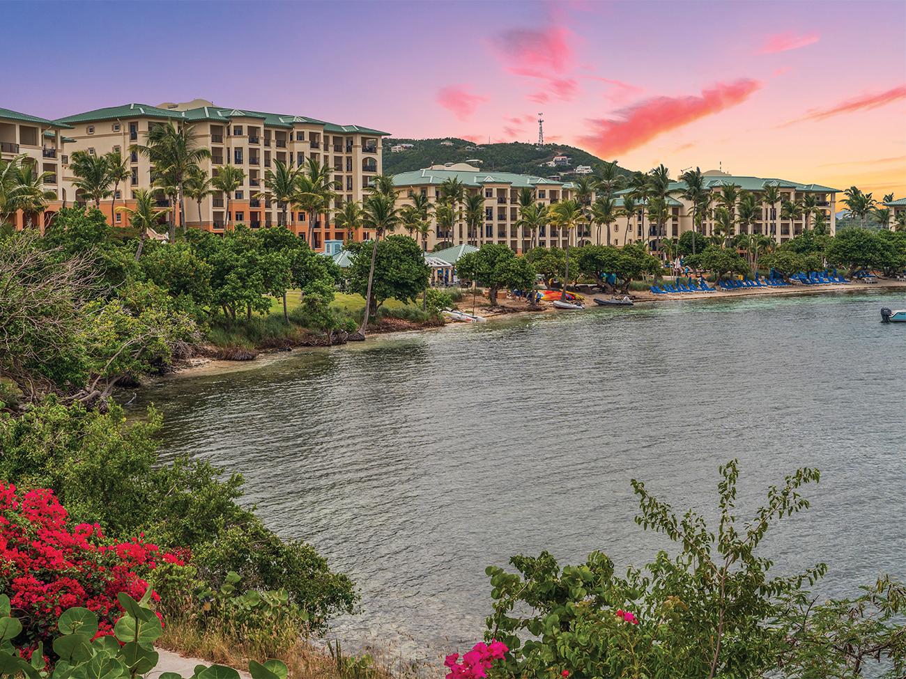 Exterior of The Ritz-Carlton Club Saint Thomas resort timeshare from the lagoon at sunset